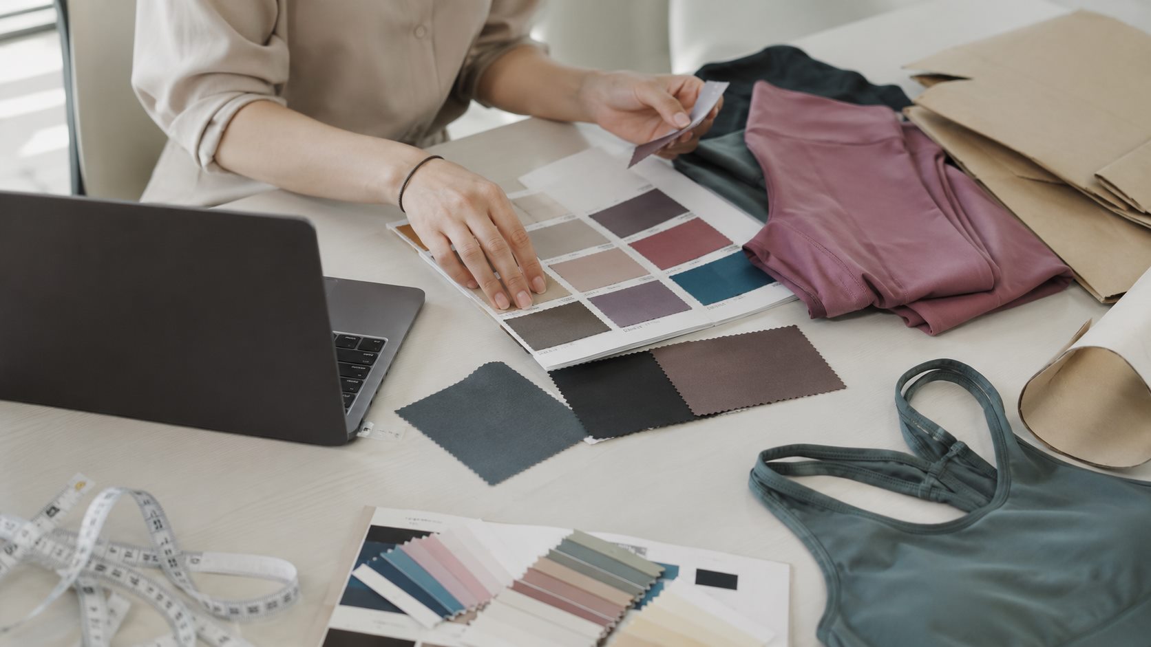 Activewear sourcing brief desk with color cards fabric swatches and sample garments
