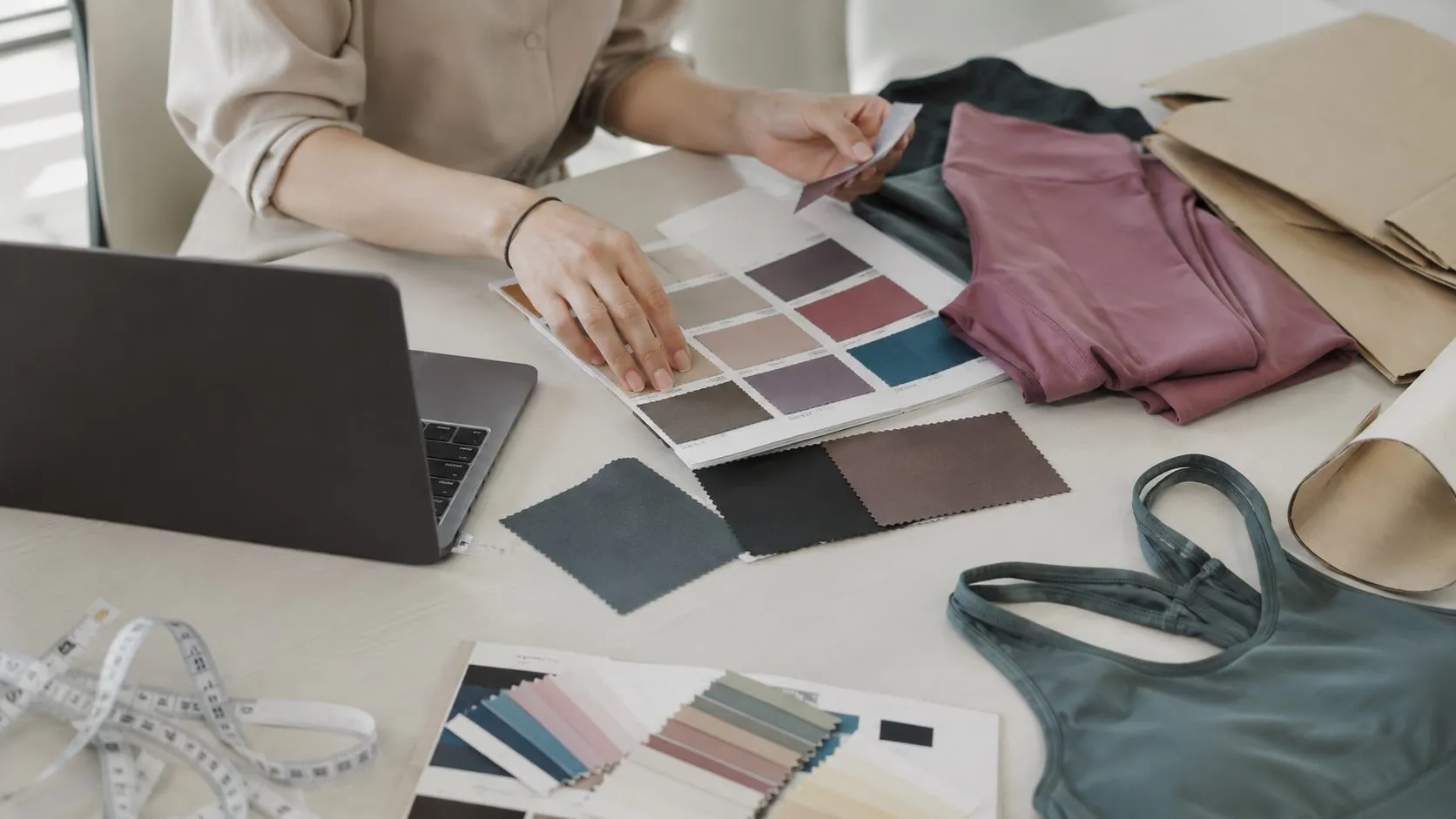 Activewear sourcing brief desk with color cards fabric swatches and sample garments