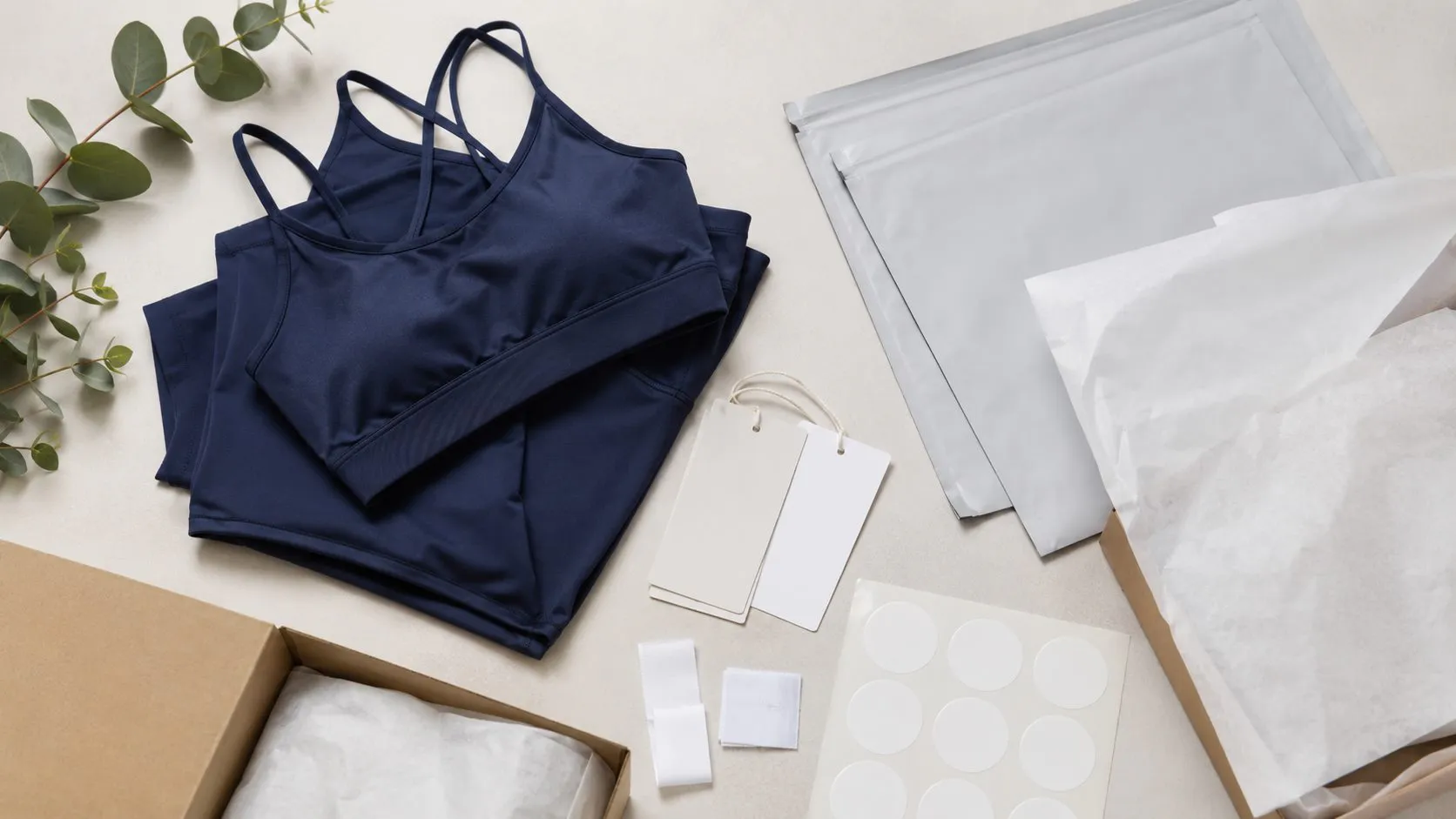 Private label boxed leggings workspace with activewear packaging and brand planning materials